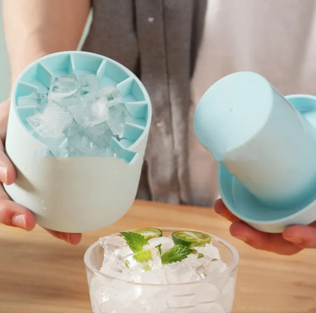 Two hands holding the Portable 2-in-1 Ice Bucket and Cube Maker with a glass of a iced drink on a wooden surface.