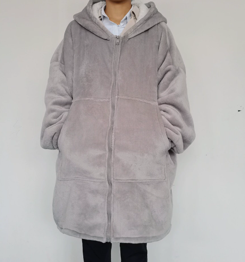 Person wearing a gray fleece jacket against a white background