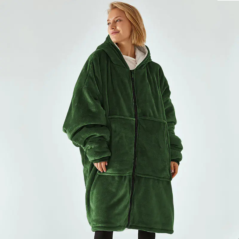 Person wearing a green fleece blanket coat on a white background
