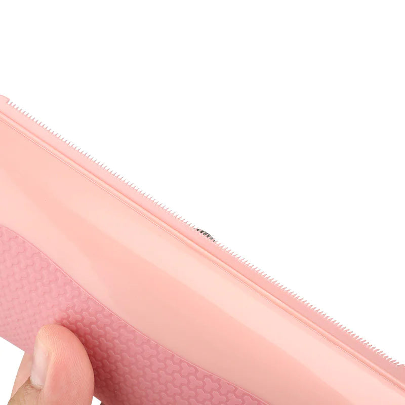 Close-up of a pink Pet Grooming Comb held by a hand on a white background
