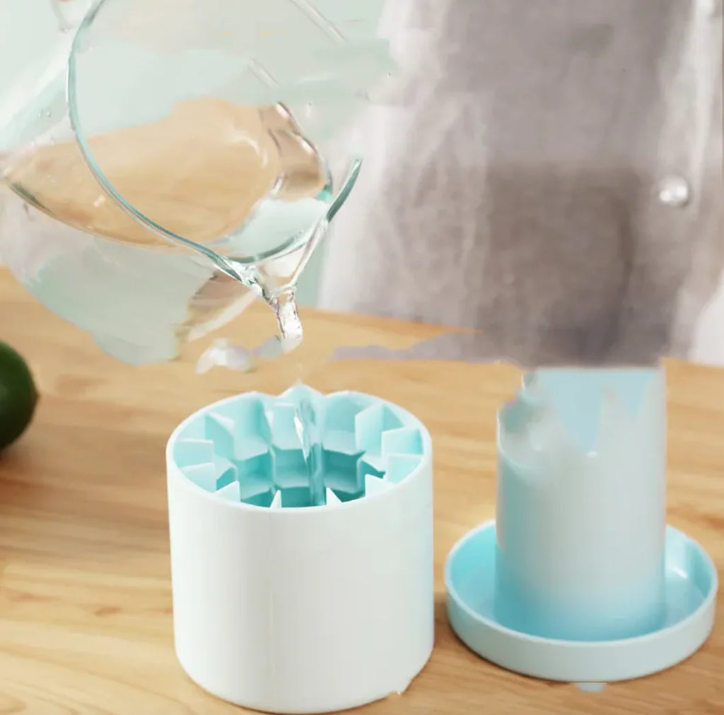 White and blue Portable 2-in-1 Ice Bucket and Cube Maker on a wooden surface with a glass container pouring liquid.
