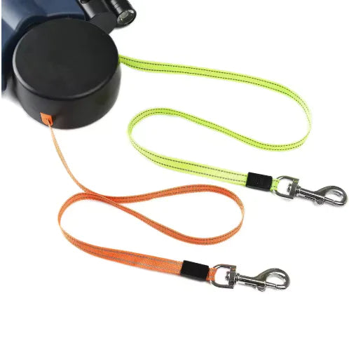 Two Auto Double Dog Leashes extended one orange and one green, with metal clips on a white background.