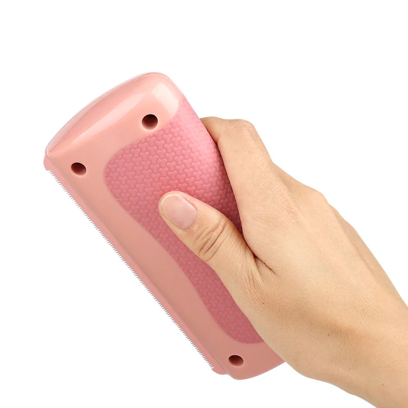Hand holding a pink Pet Grooming Comb against a white background