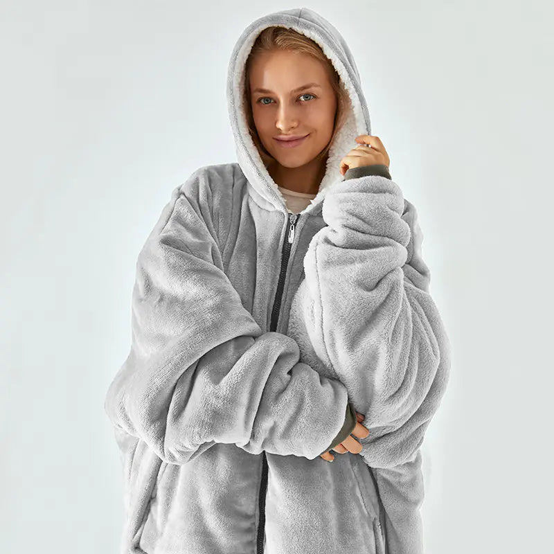Person wearing a gray fleece onesie against a white background